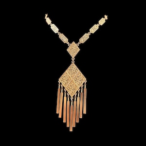 Könnte beinhalten: Eine goldfarbene Halskette mit einer Kette aus sich wiederholenden hexagonalen Filigrangliedern, die zu einem zentralen rautenförmigen Filigrananhänger führt. Der Anhänger ist mit einer Reihe vertikaler, flacher, rechteckiger goldfarbener Fransen verziert.