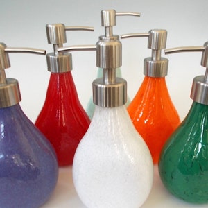 Puede incluir: Seis dispensadores de jab&oacute;n de vidrio con bombas de acero inoxidable. Los dispensadores son de varios colores: morado, rojo, verde, blanco, naranja y verde claro.