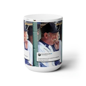 Könnte beinhalten: Eine weiße Keramiktasse mit einem Foto von Jim Leyland, einem ehemaligen Baseball-Manager, der eine Zigarette raucht. Die Tasse zeigt einen Tweet vom Account "BaseballHistoryNut", der lautet: "Herzlichen Glückwunsch an Jim Leyland für seine Aufnahme in die Baseball Hall of Fame."