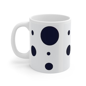 Peut inclure: Une tasse en céramique blanche avec un motif de pois noirs. Les pois sont de tailles différentes.
