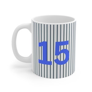 May include: White ceramic mug with a black and white striped pattern and the number 15 in blue.