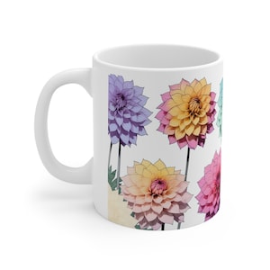 Peut inclure: Une tasse en céramique blanche avec un motif floral coloré. La tasse présente un motif de six dahlias de couleur pastel, chacune avec une combinaison de couleurs différente.