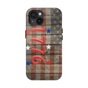 May include: A phone case with a woodgrain background and an American flag design. The number "1776" is written in red on the case, and there are red, white, and blue stars scattered around the case.
