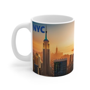 Könnte beinhalten: Weiße Keramiktasse mit einem farbenfrohen Bild der Skyline von New York City bei Sonnenuntergang. Die Tasse trägt den Text "NYC" in blauen Buchstaben.