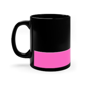Peut inclure: Une tasse à café en céramique noire avec une bande rose en bas.