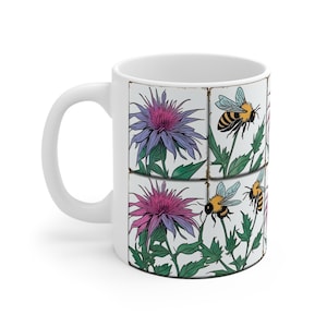 Peut inclure: Une tasse en céramique blanche avec un motif floral composé de fleurs violettes et roses et d'abeilles. Le motif est en forme de carrelage.
