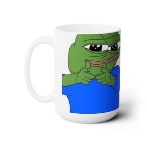 May include: White ceramic mug with a green frog meme character wearing a blue shirt and making a 'thinking' gesture with both hands.
