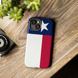 May include: A white and red phone case with a blue star and the Texas flag design. The case is designed for an iPhone.
