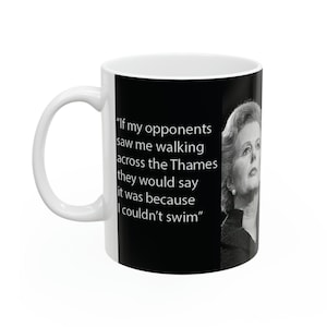 Peut inclure: Une tasse en céramique blanche avec un fond noir présentant une citation de Margaret Thatcher : « Si mes adversaires me voyaient marcher sur la Tamise, ils diraient que c'est parce que je ne sais pas nager. »