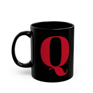 Peut inclure: Mug en céramique noire avec un grand "Q" rouge. La tasse a une anse incurvée et une finition brillante. Idéale pour le café, le thé ou toute boisson préférée.