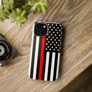 May include: A black and white phone case with a red stripe down the middle and a US flag design. The case is for an iPhone.