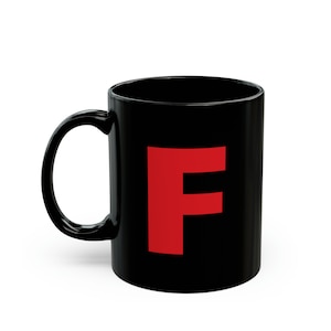 Peut inclure: Une tasse en céramique noire avec une grande lettre "F" rouge imprimée sur le devant.