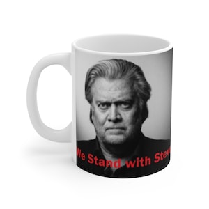 Peut inclure: Une tasse à café en céramique blanche avec une photo en noir et blanc d'un homme avec le texte "We Stand with Steve" en rouge.