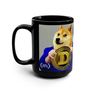 Può includere: Tazza da caffè in ceramica nera con un'immagine bianca di un cane Shiba Inu che indossa un abito blu e tiene una moneta d'oro Dogecoin. Il testo "[in]" e "1DOGECOIN" sono sulla tazza.
