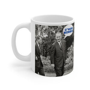 May include: White ceramic mug with a black and white photo of two men in suits walking outdoors. The text "C'mon Bobby!" is in a speech bubble above the man on the right.
