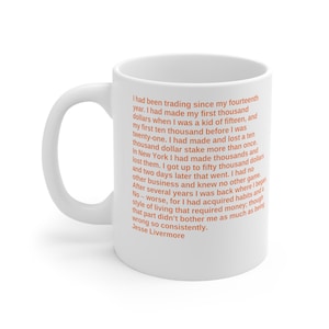 Könnte beinhalten: Weiße Keramiktasse mit schwarzem Henkel. Die Tasse zeigt ein Zitat von Jesse Livermore über Trading und Geldverdienen. Das Zitat ist in orangefarbener Schrift gedruckt.