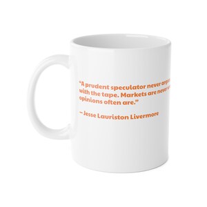 Könnte beinhalten: Eine weiße Keramiktasse mit einem Zitat von Jesse Lauriston Livermore in orangefarbener Schrift: "Ein umsichtiger Spekulant streitet nie mit dem Band. Märkte sind nie so wie Meinungen oft sind."