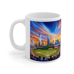 Könnte beinhalten: Weiße Keramiktasse mit einer farbenfrohen Illustration eines Baseballstadions bei Sonnenuntergang mit einer Skyline der Stadt im Hintergrund. Das Stadion ist gefüllt mit Fans, die blau und weiß tragen.