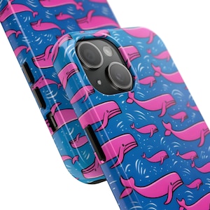 May include: A blue and pink phone case with a whale pattern. The case has a raised camera bump and a cutout for the phone's buttons.