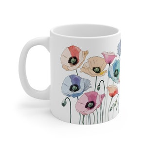 Könnte beinhalten: Weiße Keramiktasse mit einem bunten Mohnblumenmuster. Die Blumen sind in den Farben Rosa, Blau, Gelb und Rot.