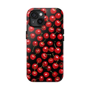 May include: A black phone case with a pattern of red cherries on a black background. The case has a raised camera bump with three lenses.