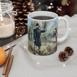 Könnte beinhalten: Eine weiße Keramiktasse mit Henkel zeigt eine Vintage-Illustration eines historischen Duells. Die Illustration zeigt drei Männer in einer Waldlandschaft, von denen einer eine Pistole abfeuert. Die Tasse ist mit einer dunklen Flüssigkeit gefüllt, wahrscheinlich Kaffee oder Tee.
