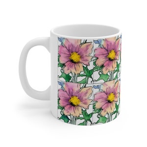 Peut inclure: Mug en céramique blanche avec un motif répété de fleurs roses et jaunes avec des feuilles vertes. Les fleurs ont un effet aquarelle.