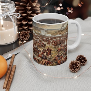 May include: White ceramic coffee mug with a colorful image of a historical battle scene featuring soldiers on horseback. The scene is set in a field with smoke and trees in the background.
