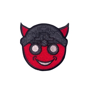 Op de afbeelding: Rode duivel emoji met zwarte ogen en een zwarte bandana. De emoji glimlacht.