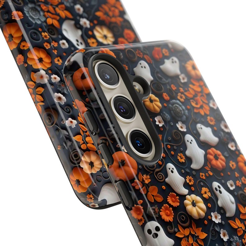 May include: A dark blue phone case with a Halloween-themed design. The case features orange pumpkins, white ghosts, and floral accents. The design is set against a dark blue background, creating a festive and seasonal look.