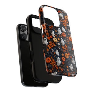 May include: A black smartphone with a protective case featuring a Halloween-themed design. The case has a pattern of white ghosts, orange pumpkins, and floral elements on a dark background. The phone is partially disassembled.