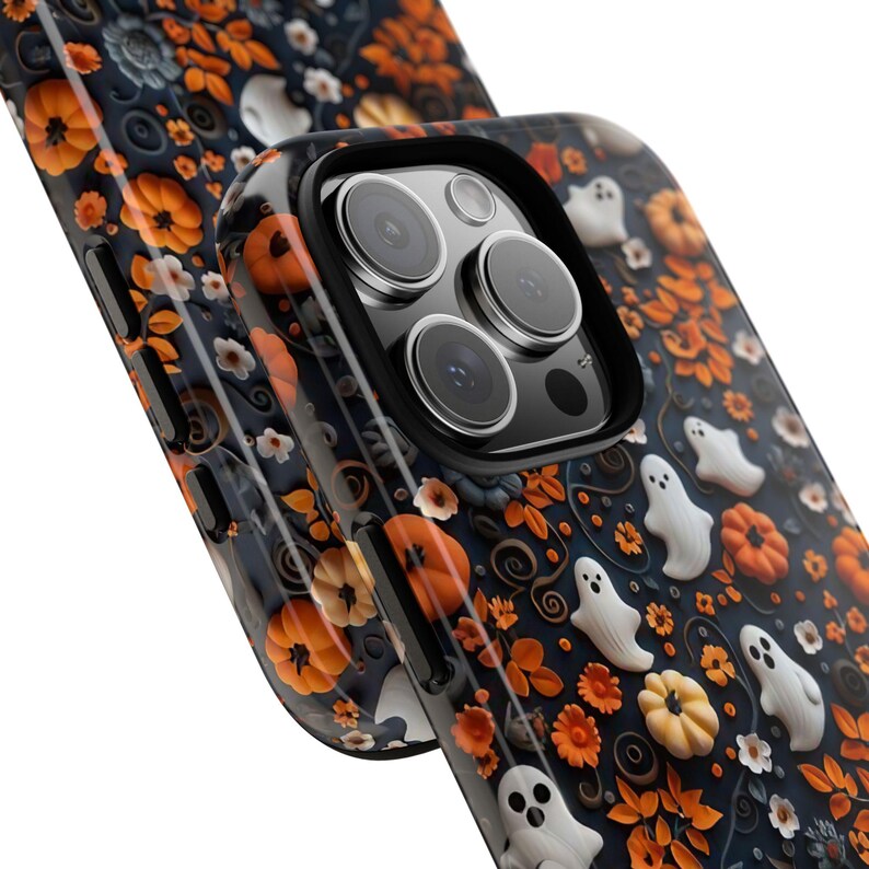 May include: A black phone case with a Halloween-themed design. The case features orange pumpkins, white ghosts, and orange flowers on a dark background. The case is designed to fit a smartphone.
