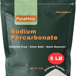Op de afbeelding: Een donkergroene hersluitbare zak met PuraMinz Sodium Percarbonate. De zak heeft oranje tekst met de tekst "Sodium Percarbonate", "Chloorvrij", "Kleurveilig" en "Vlekverwijderaar". Een rode cirkel geeft aan dat de zak 2,27 kg granulaatpoeder bevat.