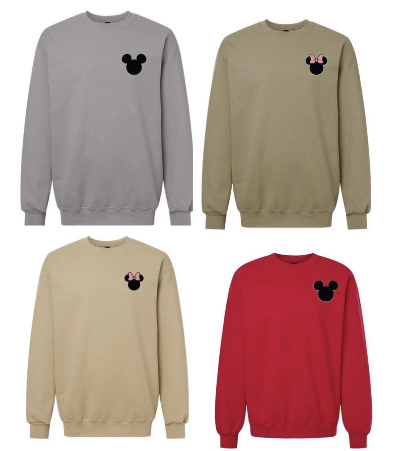 May include: Four crewneck sweatshirts in gray, tan, beige, and red. Each features a small, centered chest graphic of a black mouse silhouette. Two of the silhouettes include a small pink bow detail on the head, while two remain plain black.