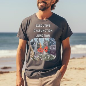 May include: A dark gray t-shirt with a graphic print of a city scene with the text "Executive Dysfunction Junction".