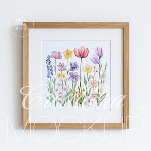 Puede incluir: Una impresión floral enmarcada con una ilustración en acuarela de varias flores coloridas, incluyendo tulipanes y violetas. La obra de arte está sobre un fondo blanco y enmarcada en un marco de madera marrón claro, creando una estética natural.