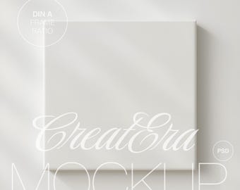 Puede incluir: Maqueta de lienzo cuadrada y blanca con el texto "Create Era MOCKUP" en una fuente cursiva delicada. La imagen incluye un gráfico "DIN A FRAME RATIO" y un gráfico "PSD", todo en un estilo minimalista.