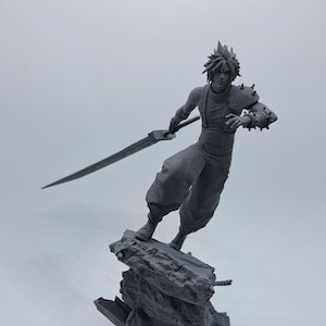 May include: A grey 3D printed figurine of a character holding a sword, standing on a rocky base.