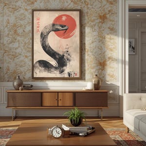 May include: A framed art print depicting a black and white snake with a red sun, inspired by Japanese art. The artwork is displayed in a living room, adding a touch of oriental style.