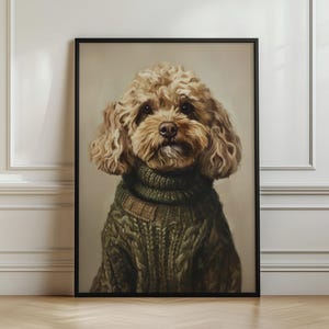 Puede incluir: Un retrato enmarcado de un perro de pelo rizado color marrón claro que lleva un grueso suéter de punto trenzado en color verde oliva oscuro con cuello alto. El perro tiene ojos y nariz oscuros sobre un fondo neutro de color beige claro.