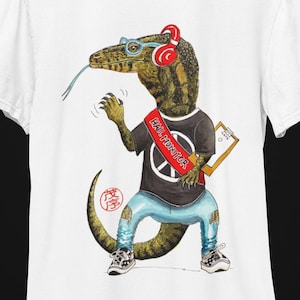 May include: White t-shirt with a graphic of a lizard wearing headphones, glasses, and a sash that says "Hall Monitor". The lizard is wearing blue jeans and sneakers.
