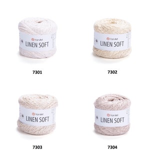 May include: Four skeins of YarnArt Linen Soft yarn in different colors: white, beige, light brown, and pink. Each skein has a label with the brand name and yarn type.