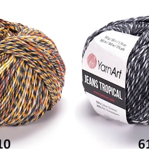 May include: Two skeins of YarnArt Jeans Tropical yarn. The skein on the left is a multi-colored yarn with orange, yellow, black, and white stripes. The skein on the right is a black and white yarn. Both skeins have a label that reads "YarnArt Jeans Tropical".