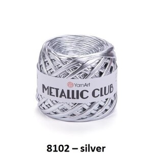 Może przedstawiać: Trzy szpulki metalicznej przędzy w kolorze liliowym, srebrnym i beżowym. Przędza jest oznaczona jako "Metallic Club", a kolory są oznaczone jako "8101 - liliowy", "8102 - srebrny" i "8103 - beżowy".