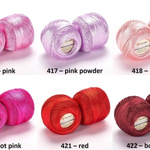 Puede incluir: Seis ovillos de hilo en varios tonos de rosa y rojo. El hilo est&aacute; etiquetado como "YarnArt" y los colores son: rosa, rosa polvo, melocot&oacute;n, rosa intenso, rojo y burdeos.