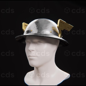 Könnte beinhalten: Ein silberner Helm mit goldenen Flügeln an der Seite. Der Helm befindet sich auf einem weißen Mannequin-Kopf.