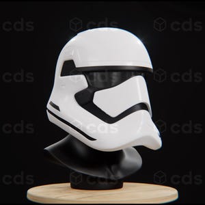 以下が含まれることがあります： 黒色の台座に置かれた白と黒のストームトルーパーのヘルメット。ヘルメットにはバイザーと前面に黒いストライプがあります。