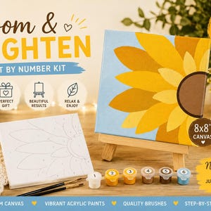 May include: A paint by number kit titled Bloom & Brighten featuring an 8x8 inch canvas with a sunflower design, a pre-printed canvas outline, six small paint pots, and two paint brushes. The kit includes everything needed for painting.