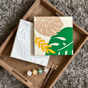 May include: A set of three ceramic mugs with a speckled, matte finish. The mugs are in shades of cream, light brown, and dark brown. Each mug has a simple, minimalist design, perfect for coffee or tea.