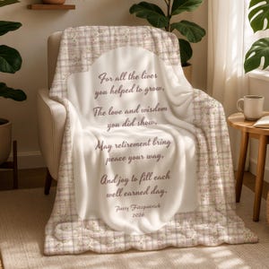 May include: A soft, white blanket draped over a chair, featuring a floral and plaid pattern border. The blanket has a central design with text that reads "For all the lives you helped to grow..." and is signed "Patty Fitzpatrick 2026."